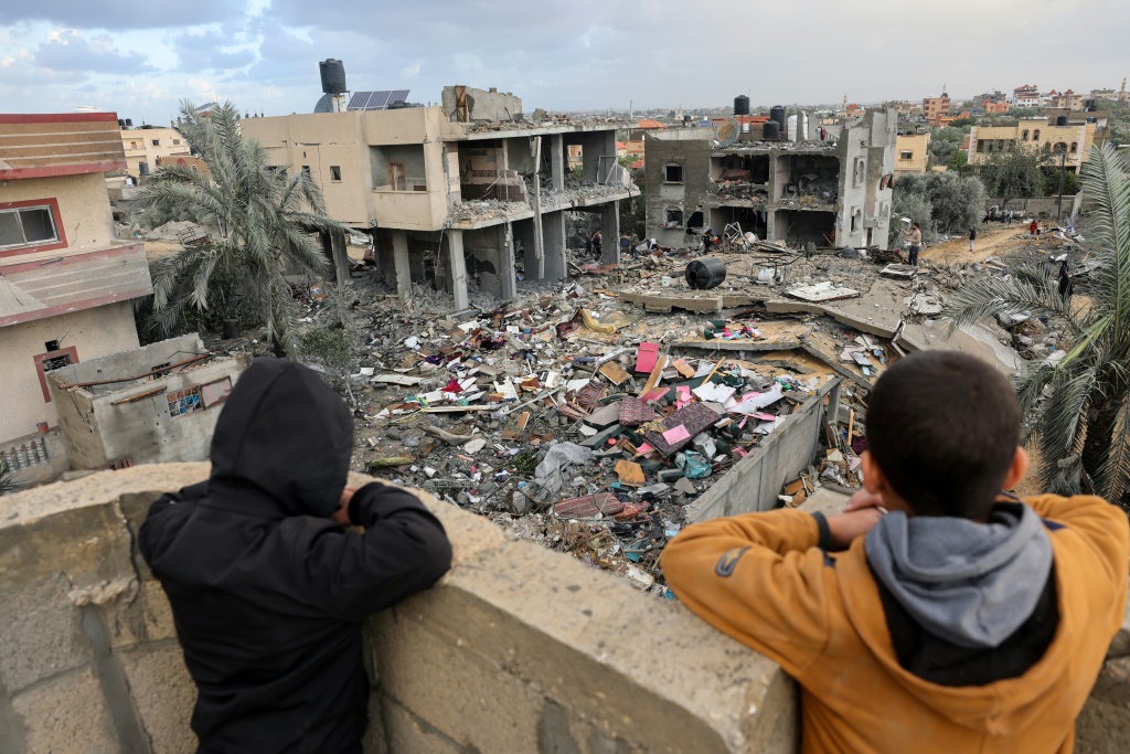 طفلان ينظران الى دمار لحق بمبانٍ في مدينة رفح جراء غارات اسرائيلية في 20 تشرين الثاني/نوفمبر 2023 (أ ف ب)
