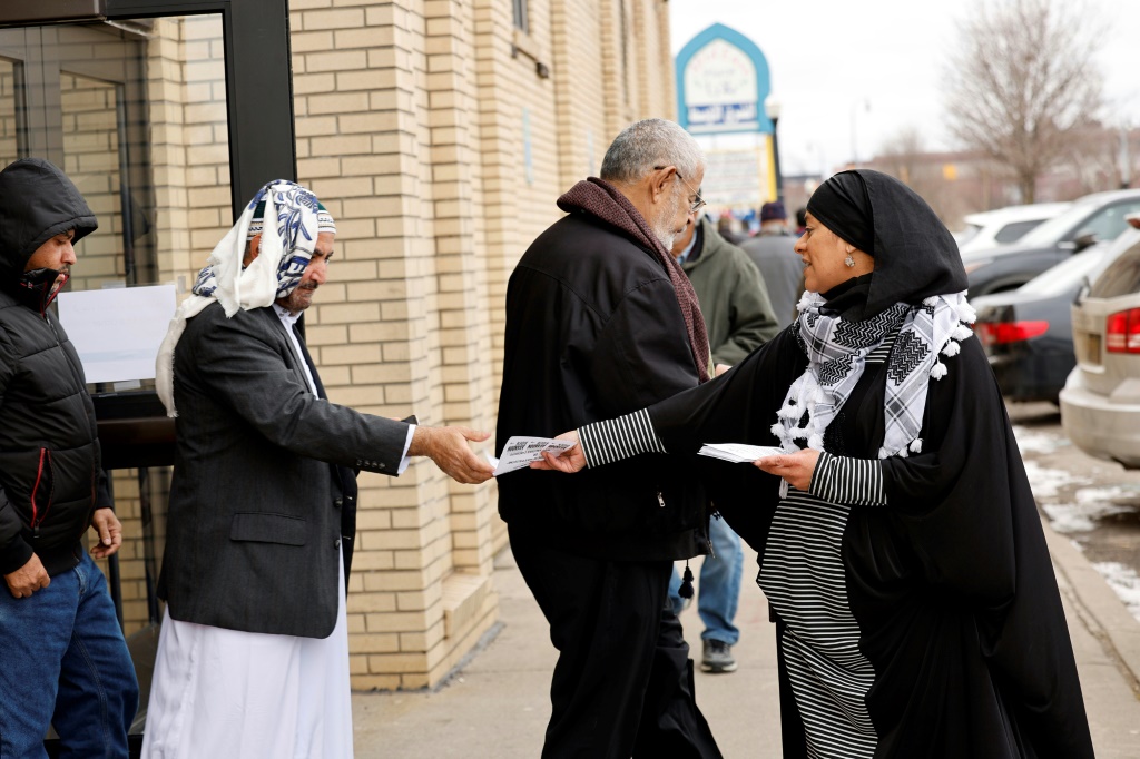 سمراء لقمان توزع منشورات أمام مسجد في ديربورن هايتس في ولاية ميشيغن الأميركية في 16 شباط/فبراير 2024 (ا ف ب)