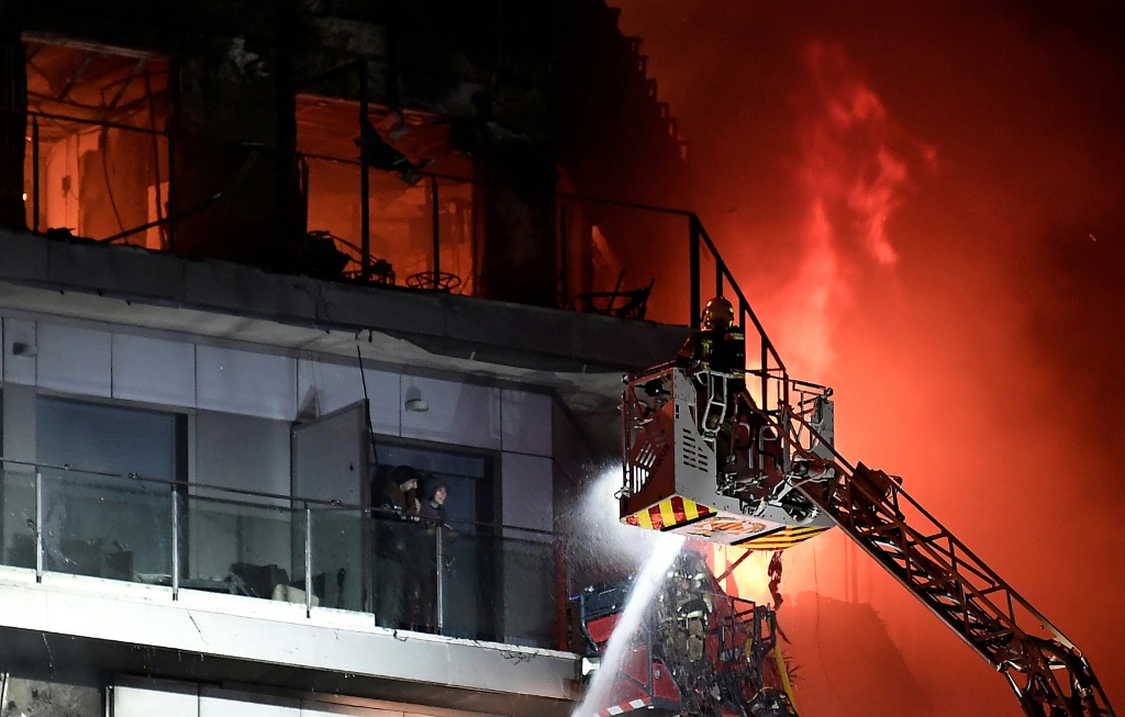 شخصان عالقان على شرفة مبنى اندلعت فيه النيران ينتظران انقاذهما في فالنسيا الإسبانية في 22 شباط/فبراير 2024 (ا ف ب)