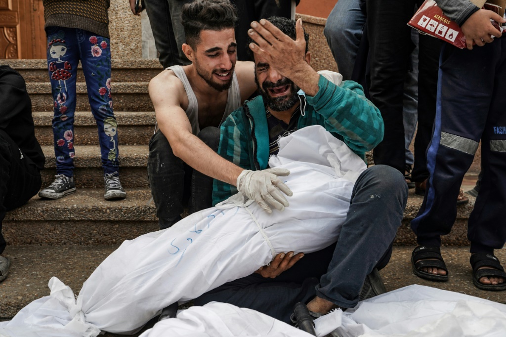 فلسطينيون يبكون أقارب لهم قضوا في قصف إسرائيلي على غزة (ا ف ب)