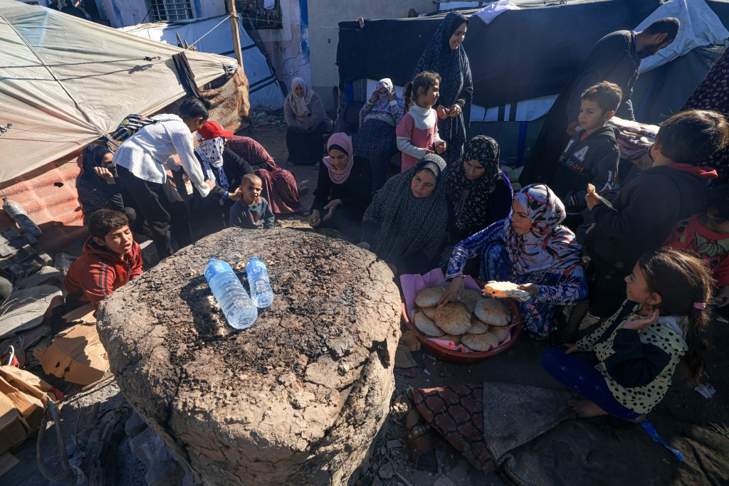 نازحون فلسطينيون يخبزون في دير البلح في قطاع غزة بتاريخ 30 تشرين الثاني نوفمبر 2023 (ا ف ب)