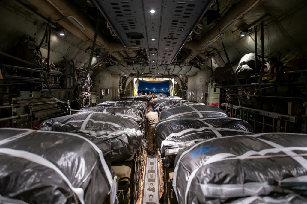 منصات المساعدات الإنسانية المجهزة بالمظلات للإسقاط الجوي فوق غزة يتم تحميلها وإعدادها للإقلاع على متن طائرة شحن عسكرية أمريكية (ا ف ب)   