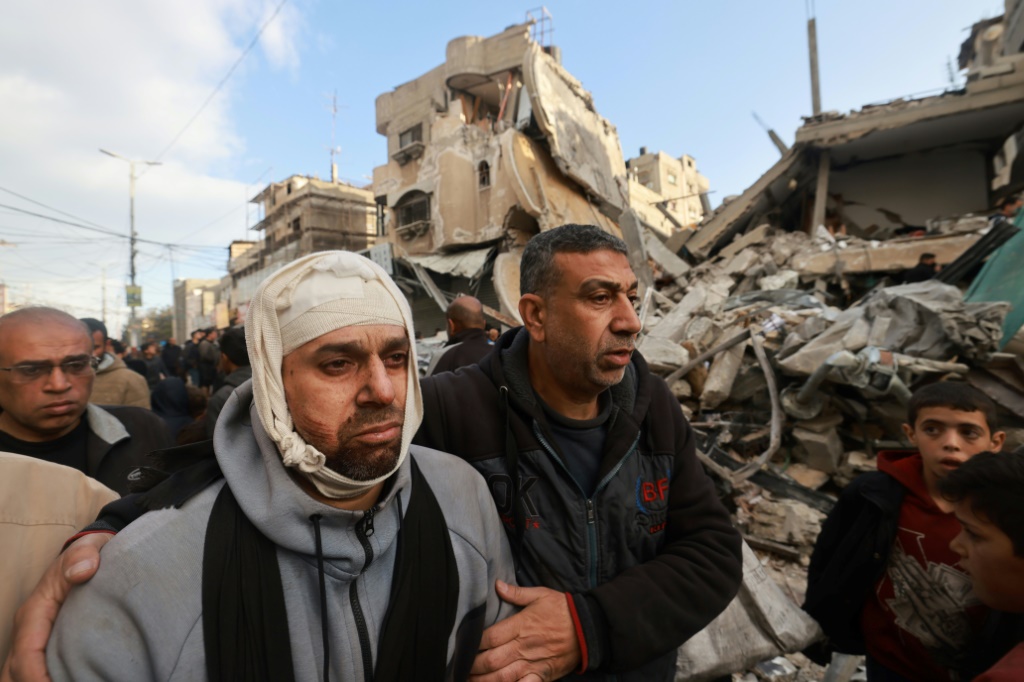 الفلسطيني الجريح نضال الغريب الذي فقد زوجته وابنته يسير أمام منزل جيرانه الذي دمره القصف الإسرائيلي في رفح بجنوب قطاع غزة في 4 آذار/مارس 2024 (ا ف ب)
