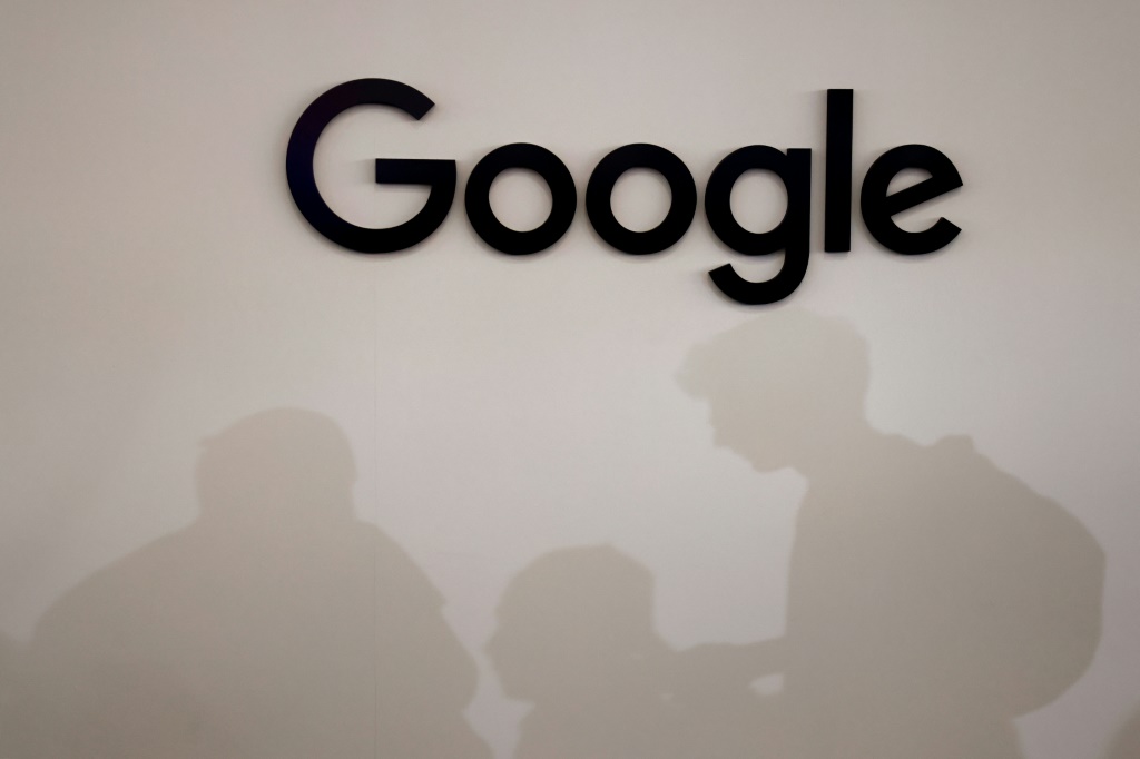 صورة ملتقطة في 15 حزيران يونيو 2023 تظهر ظلال زائرين بجوار شعار شركة التكنولوجيا الأميركية العملاقة غوغل (ا ف ب)
