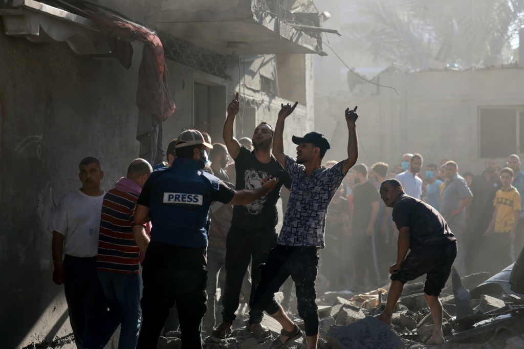 فلسطينيون يتجمعون في موقع غارة على مخيم النصيرات للاجئين في وسط قطاع غزة في 4 تشرين الثاني نوفمبر 2023 (ا ف ب)