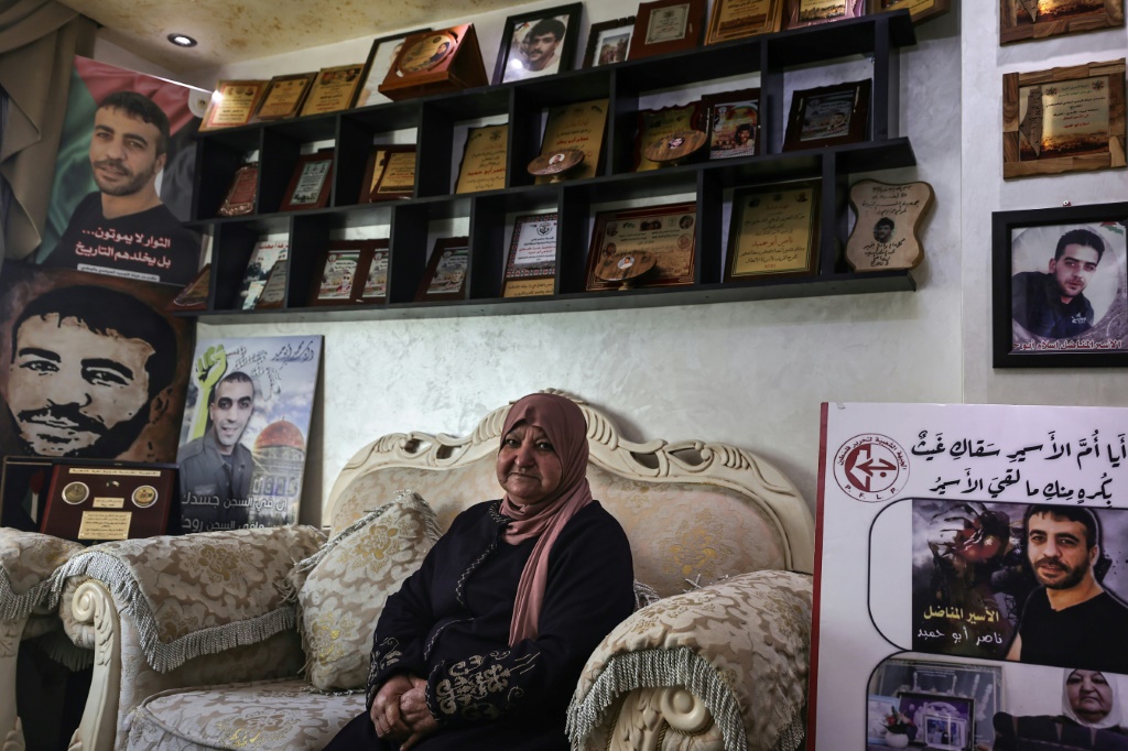 لطيفة أبو حميد (74 عاما) وسط صور أبنائها في منزلها في رام الله بتاريخ 29 شباط/فبراير 2024 (ا ف ب)