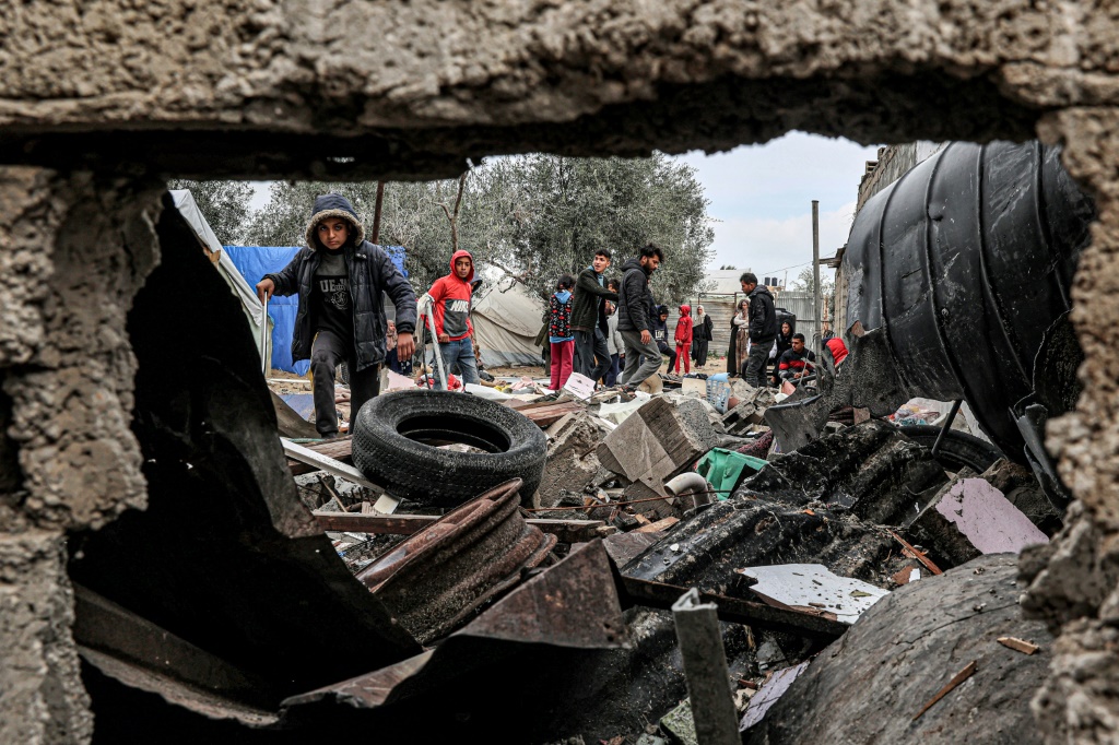 نازحون فلسطينيون يتفقدون الأضرار التي لحقت بخيامهم بعد القصف الإسرائيلي خلال الليل على مخيم رفح للاجئين في جنوب قطاع غزة في 19 آذار/مارس 2024 (ا ف ب)