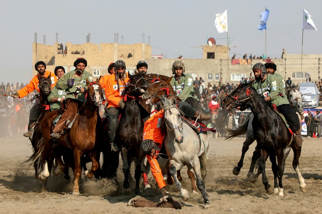 صورة ملتقطة في الثامن من آذار/مارس 2024 تظهر لاعبي فريق "ياما بتروليوم" (باللون البرتقالي) يشاركون في نهائي بطولة البوزكاشي في مدينة مزار شريف في شمال أفغانستان (ا ف ب)