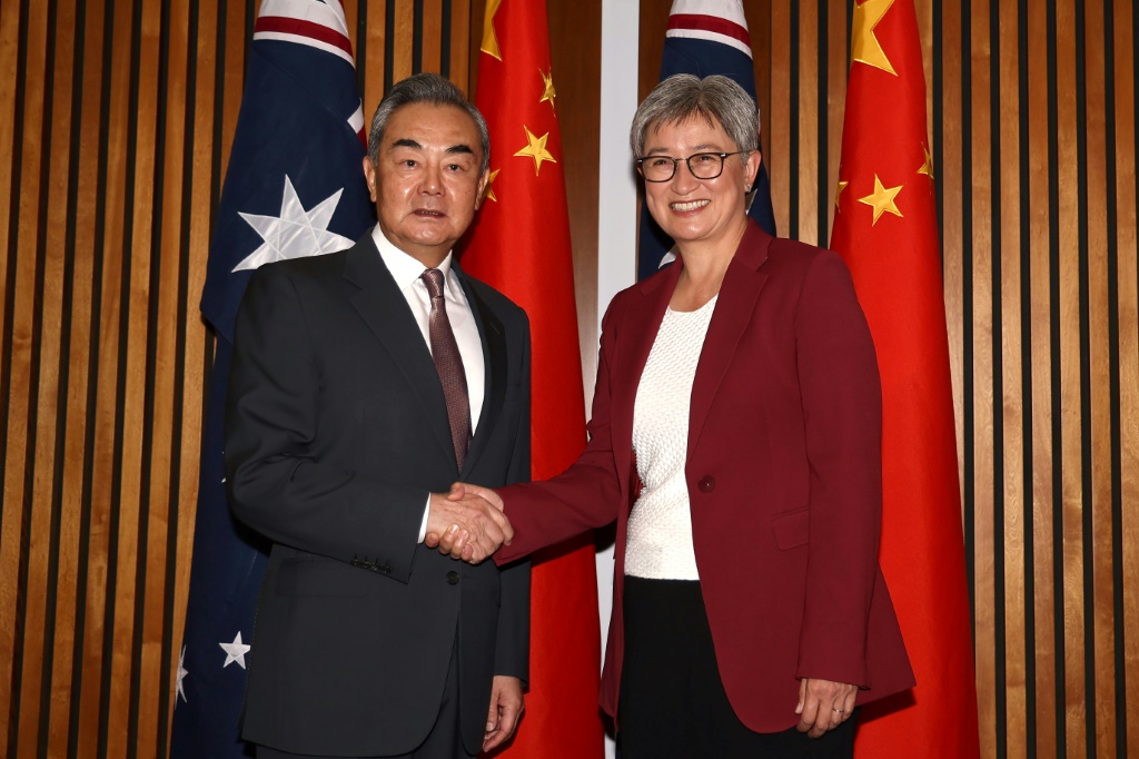 وزيرة الخارجية الأسترالية بيني وونغ (يمين) تصافح وزير الخارجية الصيني وانغ يي في كانبيرا بتاريخ 20 آذار/مارس 2024 (ا ف ب)