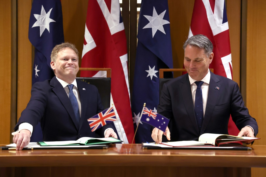 وزير الدفاع الأسترالي ريتشارد مارلس (يمين) ونظيره البريطاني غرانت شابس خلال مراسم توقيع اتفاقية دفاع في مقر البرلمان في كانبيرا في 21 آذار/مارس 2024 (أ ف ب)   