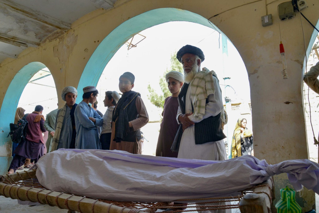 أقارب يقفون حول جثة أحد ضحايا الهجوم الانتحاري خلال مراسم تشييع في مسجد في قندهار (ا ف ب)   