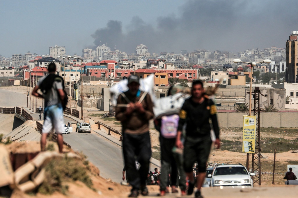 الناس يفرون مع تصاعد الدخان فوق المباني القريبة من مجمع مستشفى الشفاء أثناء القصف الإسرائيلي على مدينة غزة في 21 مارس 2024الناس يفرون مع تصاعد الدخان فوق المباني القريبة من مجمع مستشفى الشفاء أثناء القصف الإسرائيلي على مدينة غزة في 21 مارس 2024 (ا ف ب)