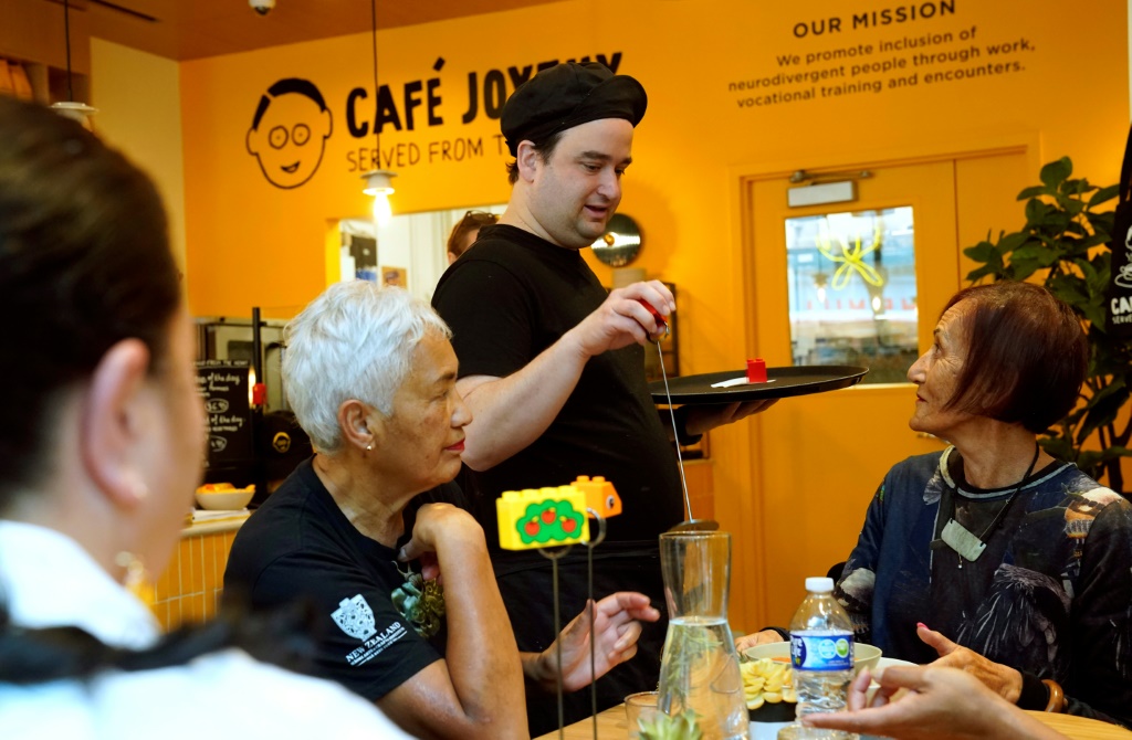 موظف أميركي من ذوي الإعاقات الذهنية يعمل نادلاً في مقهى "جوايو" في نيويورك في 15 آذار/مارس 2024 (ا ف ب)