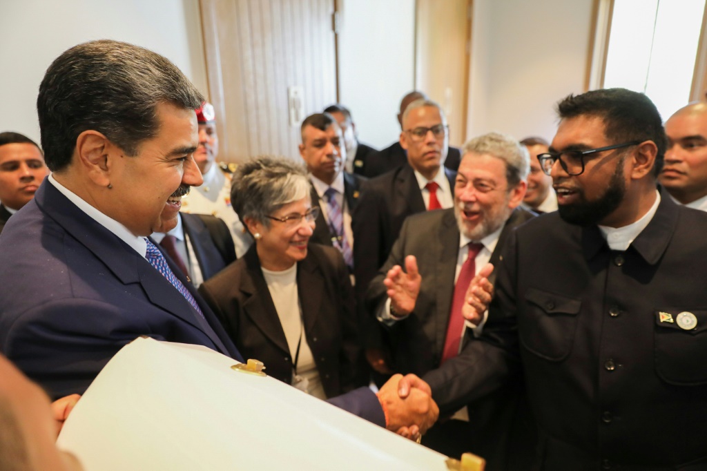 الرئيس الفنزويلي نيكولاس مادورو (يسار) يصافح رئيس غيانا عرفان علي خلال اجتماع هذا الشهر (أ ف ب)   