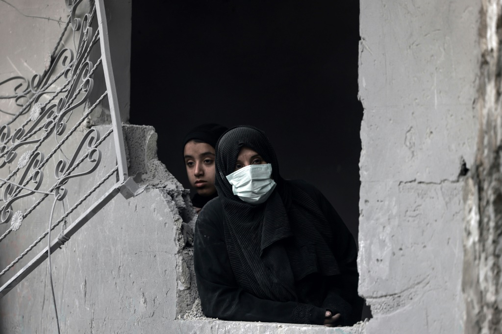 نساء يتفقّدن الأضرار بعد قصف إسرائيلي على مدينة رفح جنوب قطاع غزة، في 24 آذار/مارس 2024 (أ ف ب)  &nbsp;