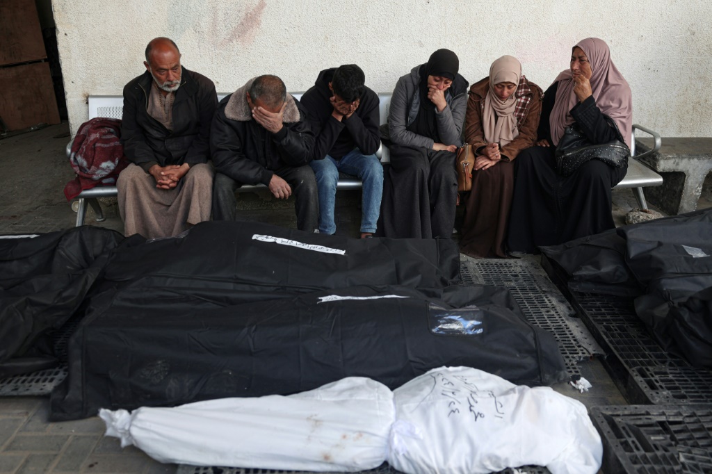 فلسطينيون يبكون أمام جثث أفراد من عائلتهم قتلوا في القصف الإسرائيلي خلال الليل، في مستشفى النجار في رفح بجنوب قطاع غزة في 25 آذار/مارس، 2024 (ا ف ب)