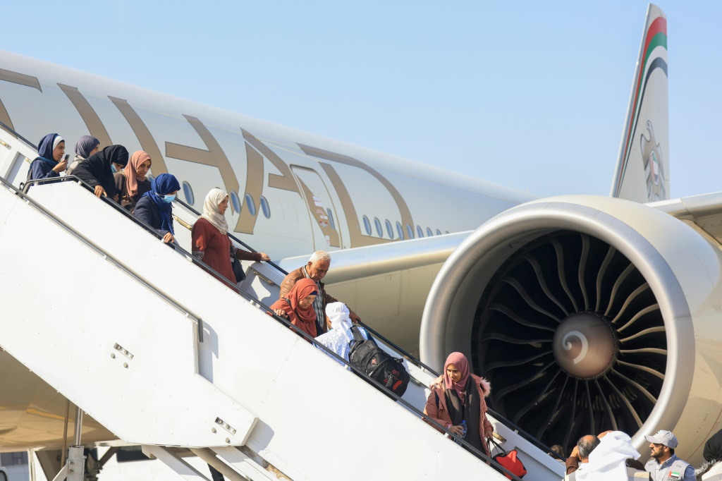 فلسطينيون تم إجلاؤهم من قطاع غزة ينزلون من طائرة قادمة من مطار العريش المصري عند هبوطها في أبو ظبي في 27 تشرين الثاني نوفمبر 2023، كجزء من مهمّة إنسانية نظّمتها الإمارات العربية المتحدة (ا ف ب)