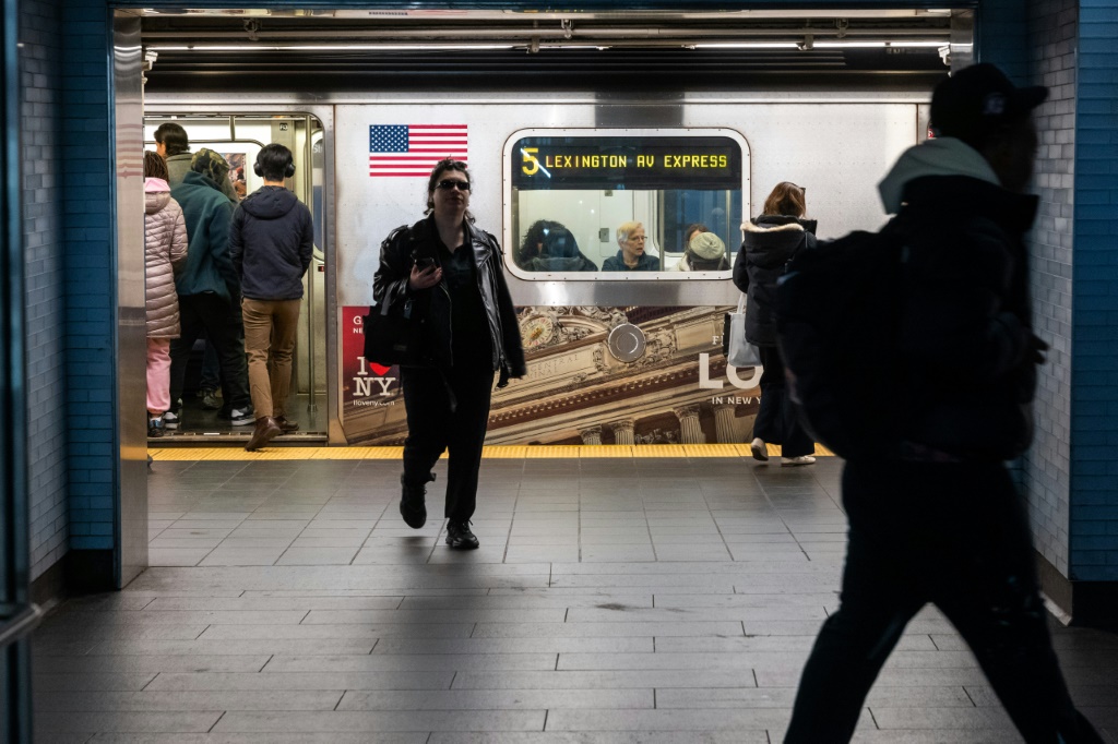 أشخاص يخرجون ويدخلون سيارة مترو أنفاق في محطة مترو أنفاق مانهاتن في مارس (ا ف ب)