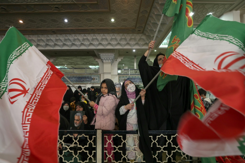 صورة مؤرخة في 3 كانون الثاني/يناير 2023 لإيرانيات يرفعن علم بلادهن في طهران (أ ف ب)   