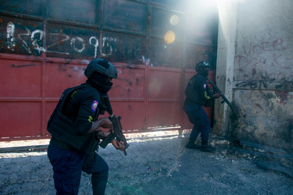 ضباط شرطة مسلحون يراقبون أحد الشوارع بعد عنف العصابات مساء يوم 21 مارس 2024، في بورت أو برنس، هايتي (ا ف ب)