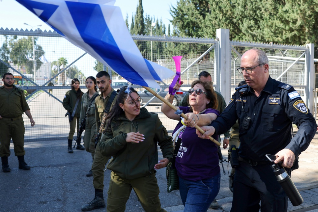 متظاهرون ويهود متدينون خارج مكتب تجنيد للجيش في بلدة كريات أونو، بالقرب من تل أبيب، في 5 آذار/مارس 2024، خلال مظاهرة ضد إعفائهم من الخدمة العسكرية (أ ف ب)   