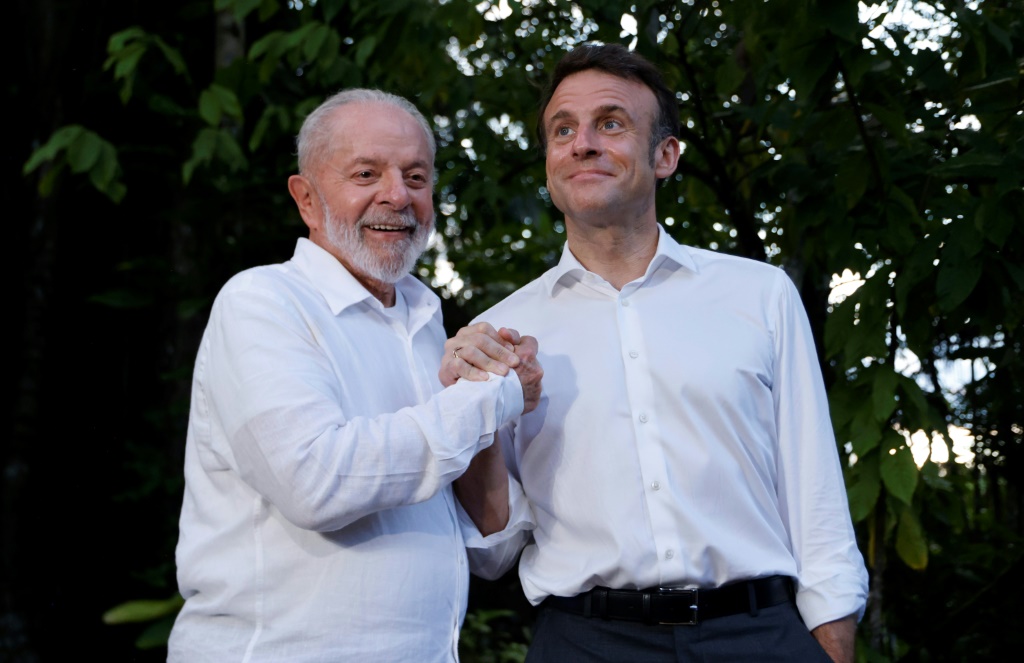 الرئيس البرازيلي لويز إيناسيو لولا دا سيلفا (يسار) والرئيس الفرنسي إيمانويل ماكرون يبتسمان معًا في جزيرة كومبو بالبرازيل في 26 مارس 2024 (أ ف ب)   