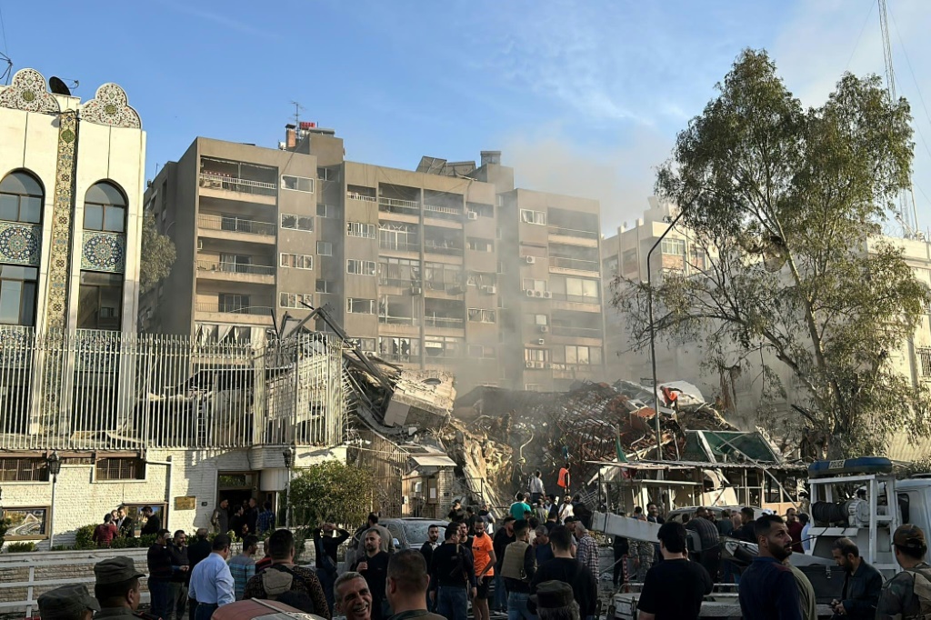    أفراد الطوارئ والأمن يتجمعون في موقع الضربات التي ضربت مبنى مجاور للسفارة الإيرانية في العاصمة السورية دمشق، في 1 أبريل 2024 (أ ف ب)   