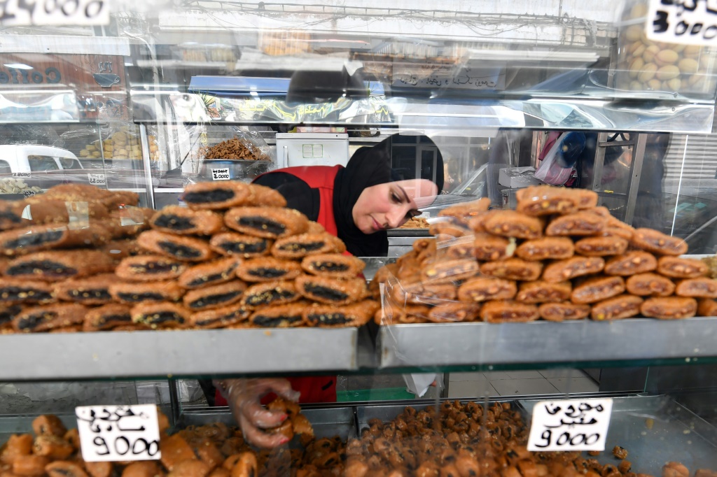 عاملة في محل حلويات بالعاصمة تونس تزن بعضا من حلوى 