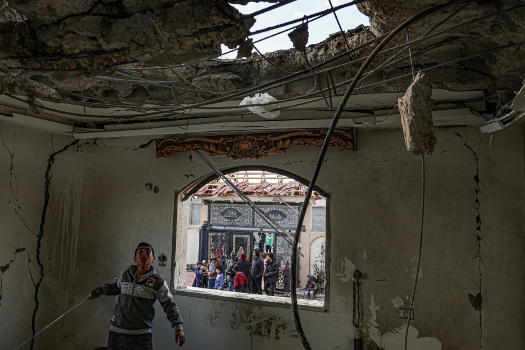 شاب فلسطيني ينظر إلى الأضرار التي خلفها قصف إسرائيلي على مدينة رفح جنوب قطاع غزة في 22 مارس 2024 (ا ف ب)