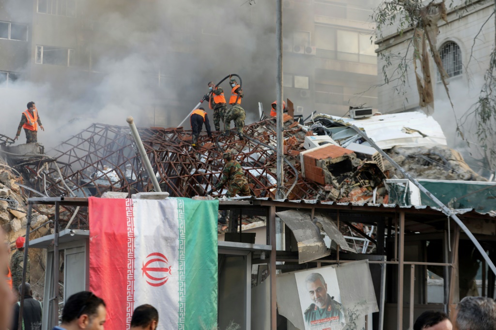 أثناء إخماد النيران بعد القصف الذي استهدف مبنى القنصلية الإيرانية في دمشق في الأول من نيسان/أبريل 2024 (أ ف ب)   