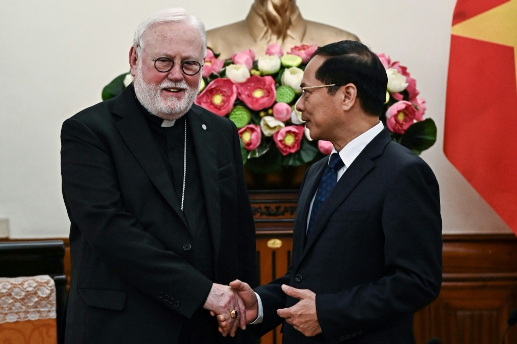 وزير خارجية فيتنام بوي ثانه سون يصافح وزير خارجية الفاتيكان الفعلي رئيس الأساقفة بول غالاغر (ا ف ب)