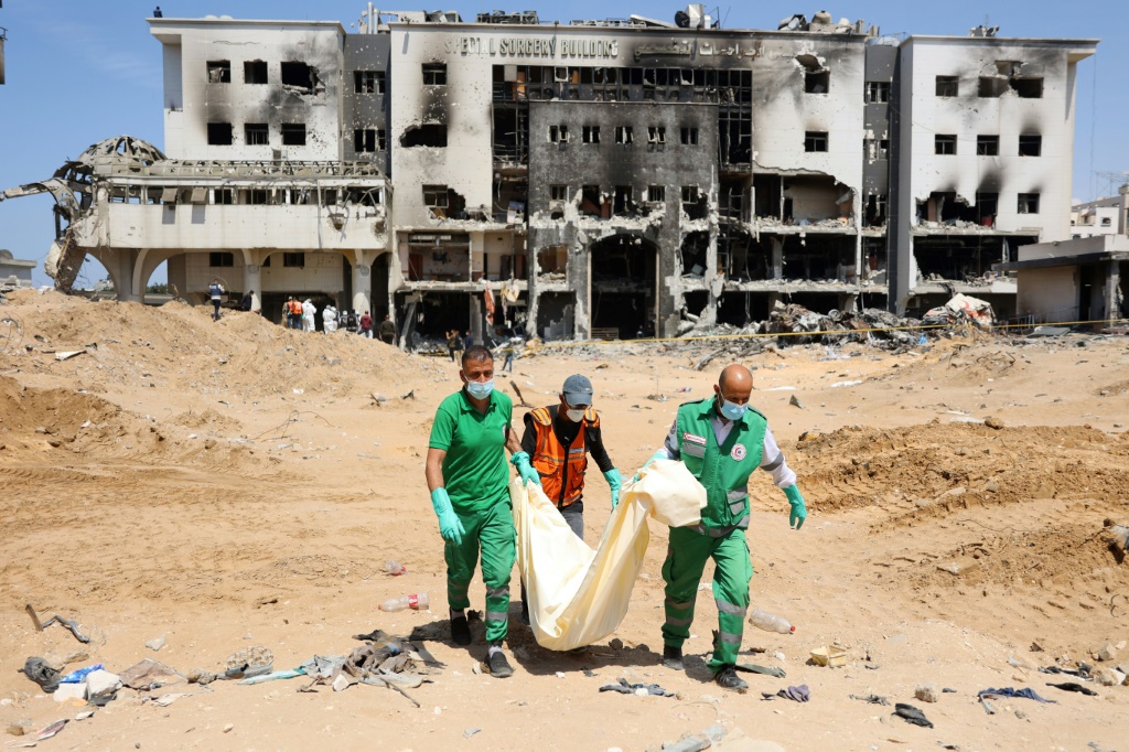 عمال الطب الشرعي والدفاع المدني الفلسطينيون ينتشلون بقايا بشرية من أرض مستشفى الشفاء الذي دمرته غارة إسرائيلية استمرت أسبوعين (أ ف ب)  &nbsp;