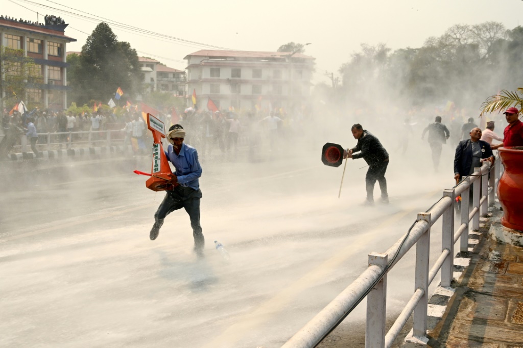 أفراد الأمن النيباليون يستخدمون خراطيم المياه لتفريق المتظاهرين المؤيدين للنظام الملكي، مع تزايد الاستياء بسبب عدم الاستقرار السياسي والفساد وبطء التنمية الاقتصادية (أ ف ب)   