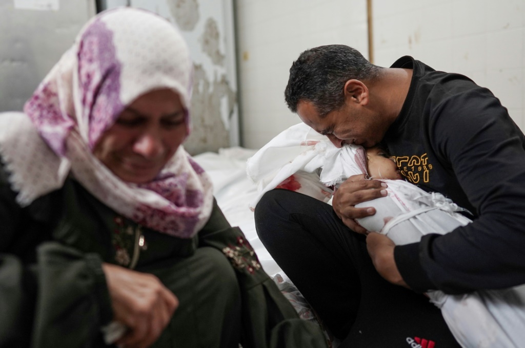 فلسطينيون ينعون أفراد عائلاتهم الذين قتلوا في القصف الإسرائيلي خلال الليل على مخيم النصيرات للاجئين وسط غزة، في مستشفى شهداء الأقصى في دير البلح في 10 أبريل 2024 (ا ف ب)