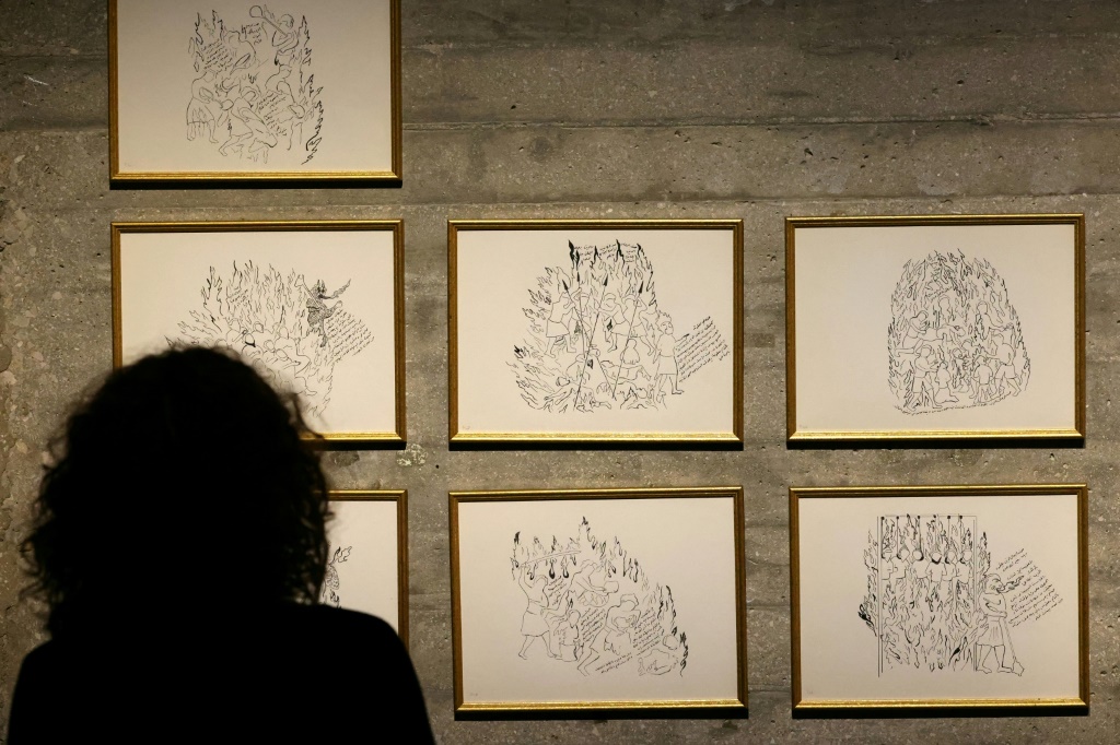 زائرة تعاين أعمالاً في معرض بعنوان "عن الكوميديا البشرية" يضم رسومات استوحاها الفنان الإسباني سلفادور دالي من "الكوميديا الإلهية" للشاعر الإيطالي دانتي، في مركز مينا للصورة في بيروت في 5 نيسان/أبريل 2024 (ا ف ب)