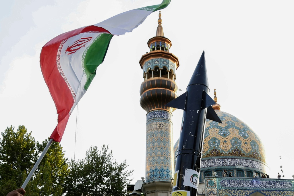 رفع العلم الإيراني ومجسم لصاروخ في ساحة فلسطين بوسط طهران في 15 نيسان/إبريل 2024 غداة الهجوم الإيراني على إسرائيل (ا ف ب)