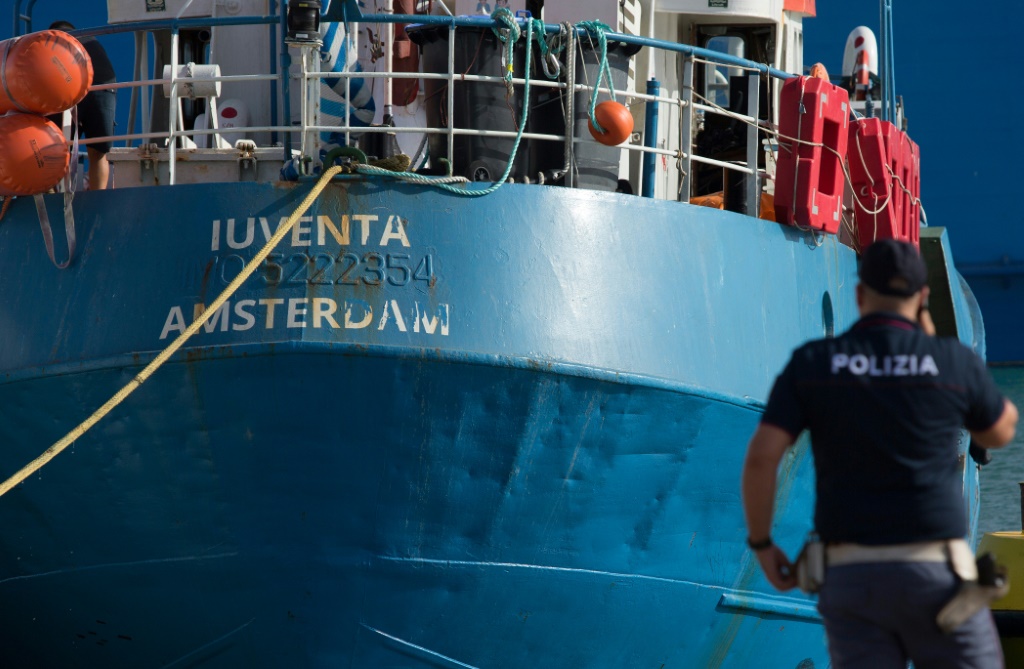 ضابط شرطة إيطالي يقف بجانب سفينة الإنقاذ Iuventa التي تديرها المنظمة الألمانية غير الحكومية Jugend Rettet (ينقذ الشباب) (أ ف ب)