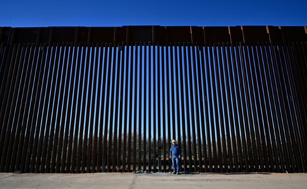 المزارع الأميركي جون لاد أما الجدار الحدودي بيم الولايات المتحدة والمكسيك بالقرب من بالوميناس في ولاية أريزونا الأميركية في 17 نيسان/ابريل 2024 (أ ف ب)   