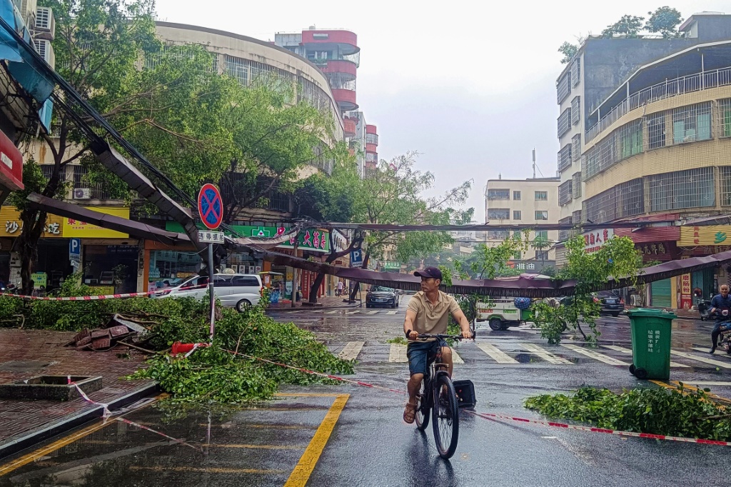 رجل يركب درّاجته بعد هطول أمطار غزيرة في مدينة تشينغيوان في مقاطعة قوانغدونغ جنوب الصين في 22 نيسان/أبريل 2024 (ا ف ب)