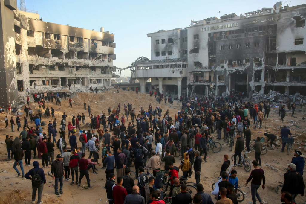 فلسطينيون يتفقدون الدمار في مجمع الشفاء الطبي في مدينة غزة بعد انسحاب الجيش الإسرائيلي في الأول من نيسان/أبريل 2024 (ا ف ب)