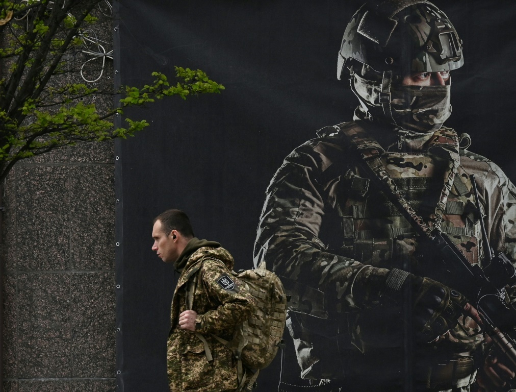 جندي أوكراني يمر أمام ملصق تجنيد في كييف في 23 أبريل 2024 (أ ف ب)   