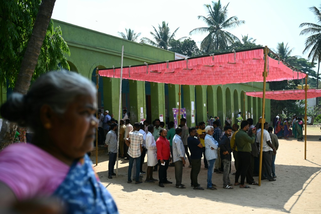  ناخبون في الهند ينتظرون التصويت وهم يحتمون من اشعة الشمس تحت مظلة في بنغالور في 26 نيسان/أبريل 2024 (ا ف ب)