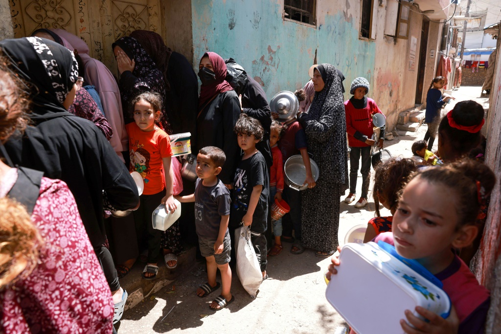 أطفال فلسطينيون نازحون يصطفون للحصول على الطعام في رفح جنوب قطاع غزة في 19 نيسان/أبريل 2024 (ا ف ب)