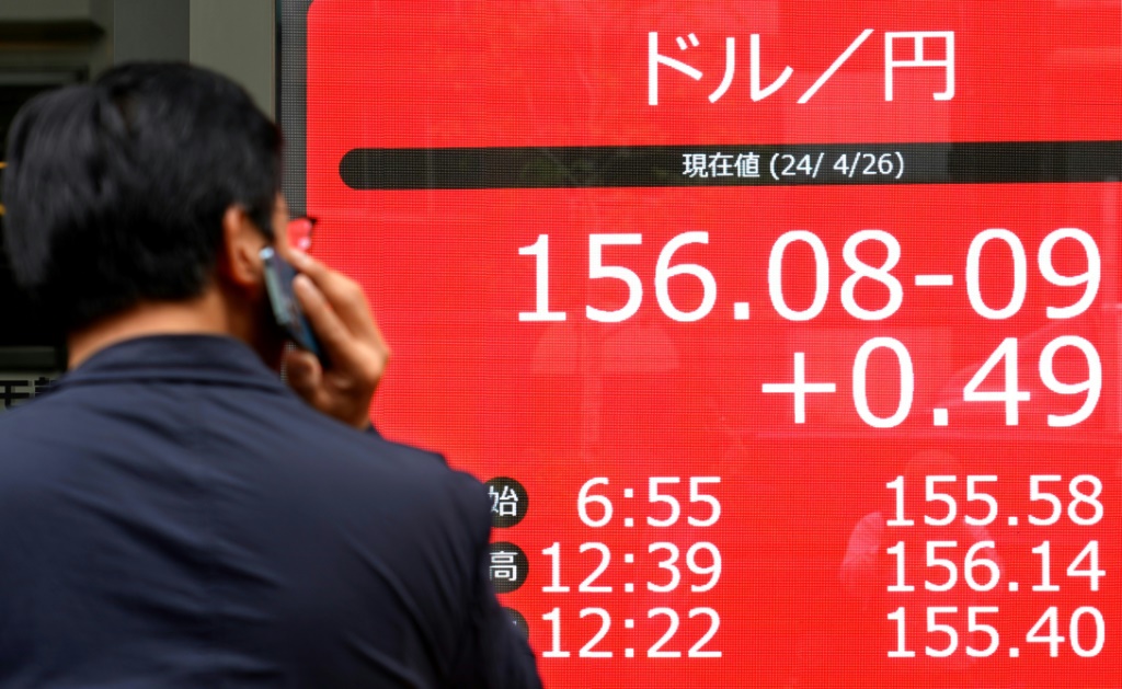 رجل ينظر إلى لوحة إلكترونية تعرض سعر صرف الين الياباني مقابل الدولار الأميركي في طوكيو في 26 نيسان/أبريل 2024 (أ ف ب)   