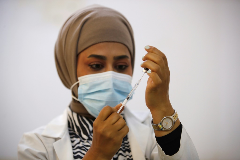 ممرضة تعد لقاحا ضج الحصبة في مدرسة في بغداد في 14 نيسان/أبريل 2024 (ا ف ب)