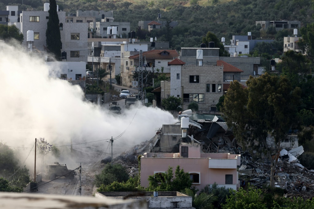 دخان يتصاعد من أحد المباني أثناء مداهمة القوات الإسرائيلية لبلدة دير الغصون بالضفة الغربية المحتلة بالقرب من طولكرم في 4 أيار/مايو 2024 (ا ف ب)
