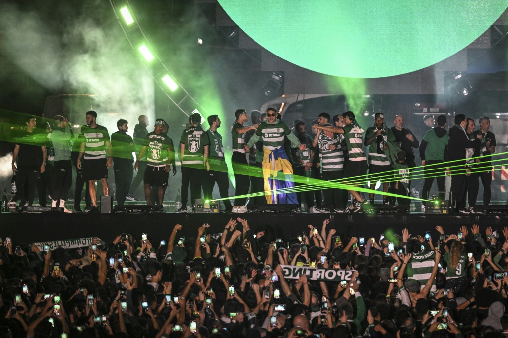 لاعبو سبورتينغ وبينهم الهداف السويدي فيكتور غيوكيريس (وسط) يحتفلون مع الجمهور في ساحة ماركيس دو بوميل في لشبونة بعد حسم لقب الدوري البرتغالي لكرة القدم (ا ف ب)