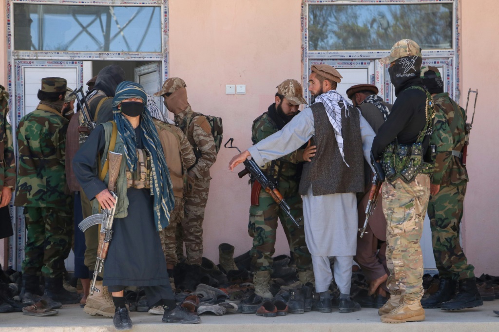 أفراد أمن مسلحون من حركة طالبان يقومون بتفتيش الناس عند مدخل مسجد في منطقة أرغو بولاية بدخشان (أ ف ب)   