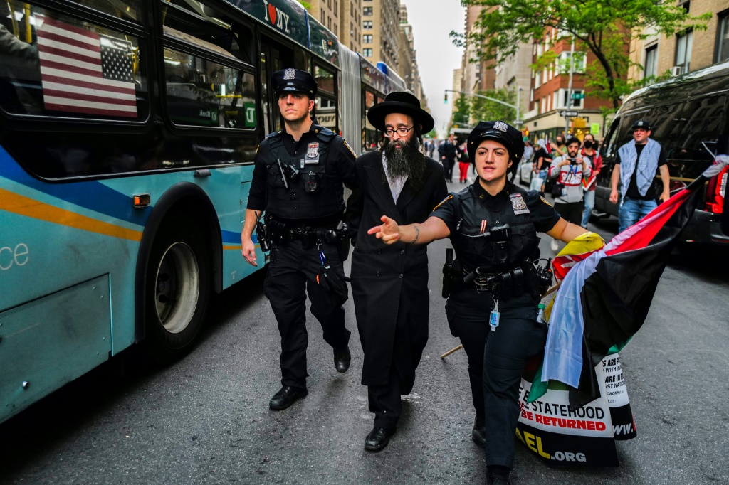 عناصر الشرطة توقف متظاهرا يهوديا مؤيدا للفلسطينيين في محيط متحف متروبوليتان في نيويورك بتاريخ السادس من أيار/مايو 2024 (ا ف ب)