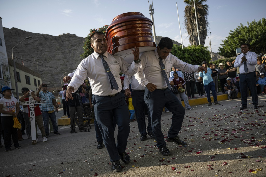  راقصو الموت في بيرو يظهرون حركات معقدة وهم يحملون التابوت إلى مثواه الأخير (أ ف ب)